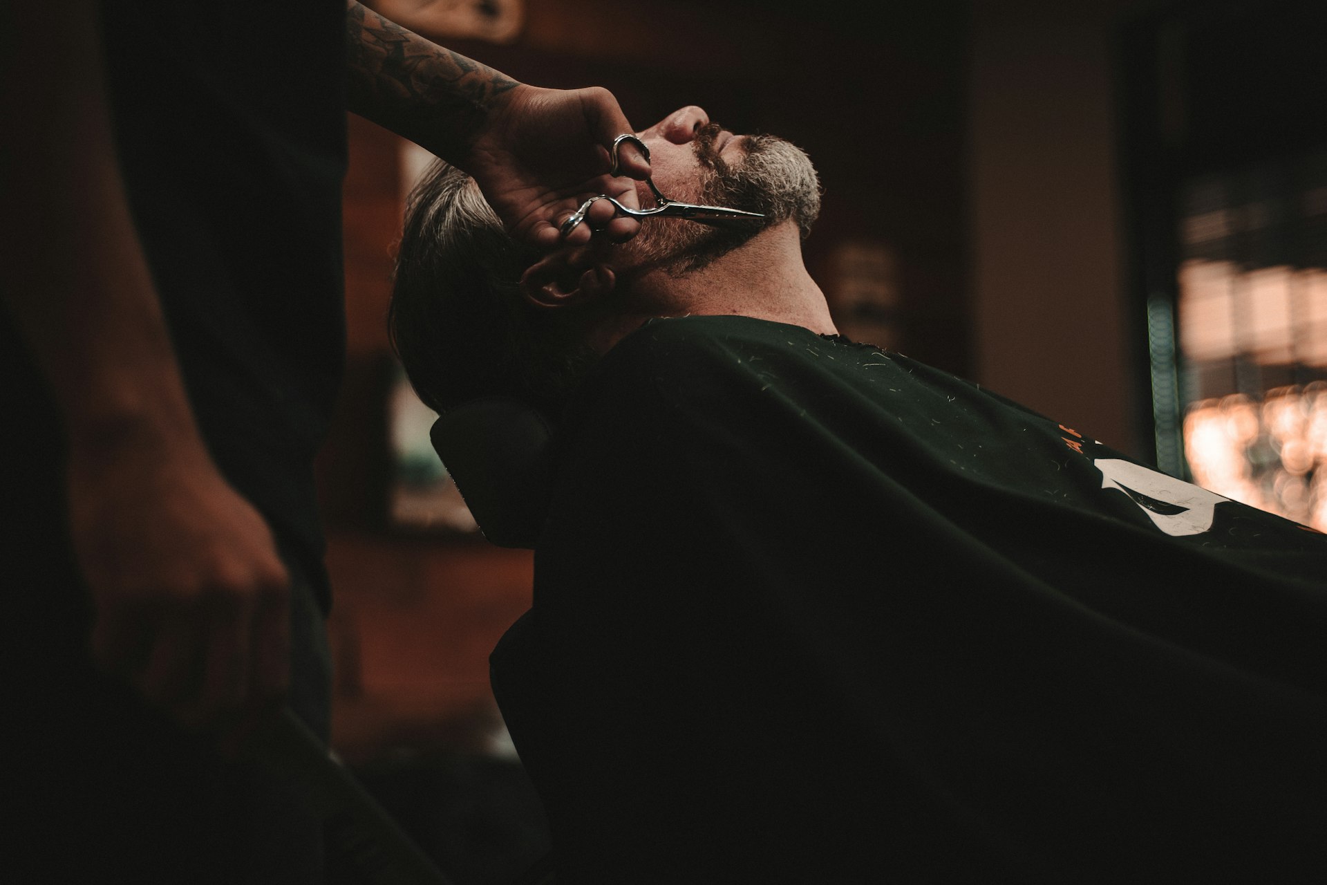 Εσωτερικό του Aurelio Barber Shop House με δερμάτινες καρέκλες και ζεστό φωτισμό